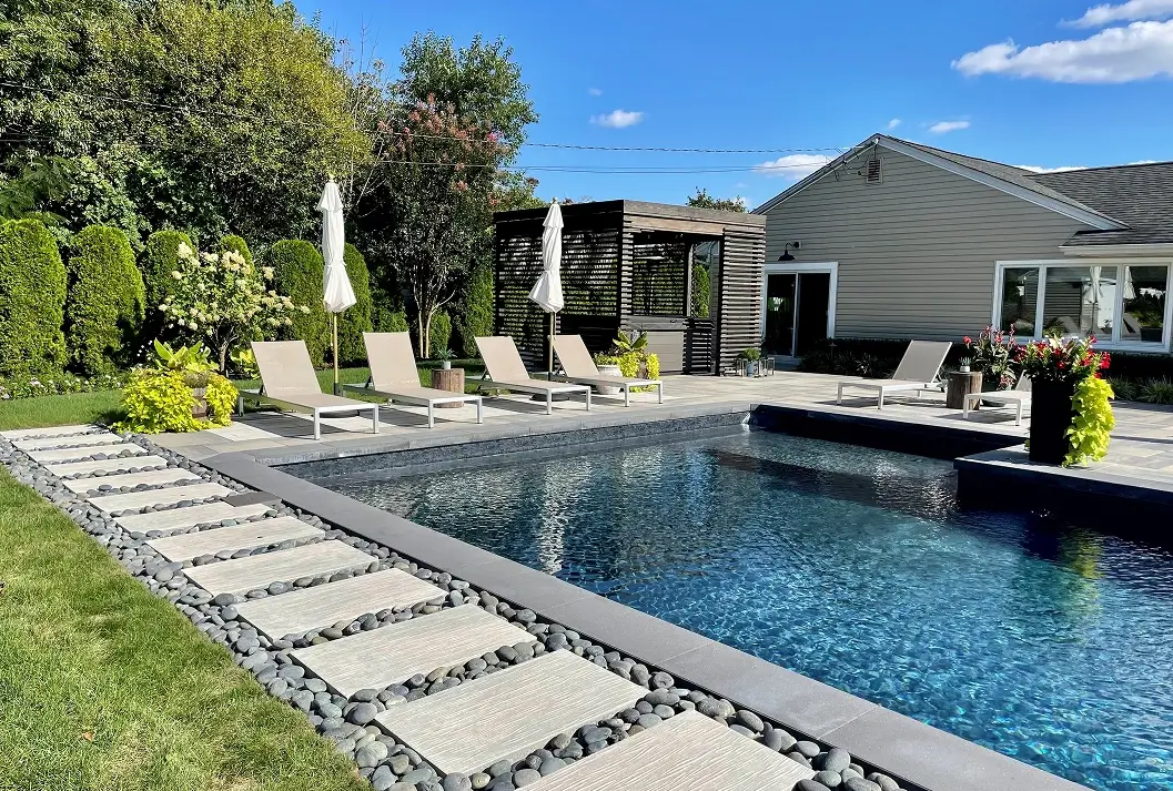 Rectangular vinyl liner pool with stepping stone walkway and sun loungers.