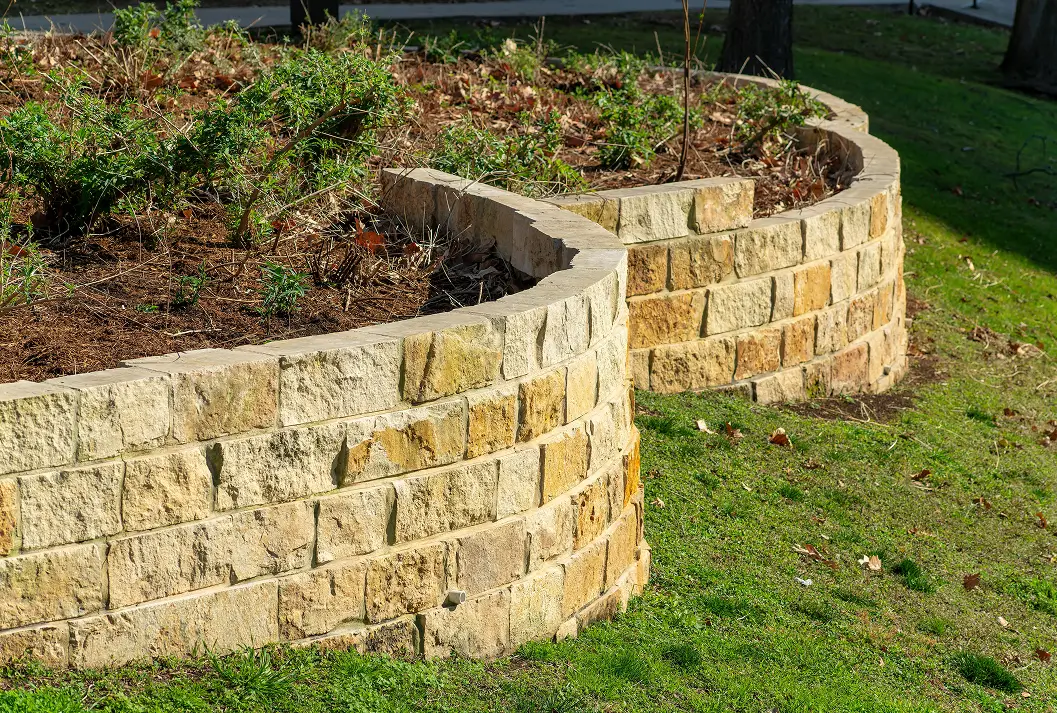 Tiered curved stone retaining walls on a grassy hillside.